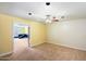 Bedroom with carpet flooring, a ceiling fan, and a peek into the adjacent colorful room at 18256 N 75Th Ave, Glendale, AZ 85308
