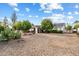 Charming single-story home with mature trees and low-maintenance desert landscaping under a bright blue sky at 18256 N 75Th Ave, Glendale, AZ 85308