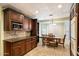 Eat-in kitchen featuring rich wood cabinetry, granite countertops, and views through bright windows at 18256 N 75Th Ave, Glendale, AZ 85308