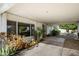 A covered patio featuring lush plants and shade, with a glimpse of the outdoors through large windows at 18256 N 75Th Ave, Glendale, AZ 85308