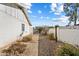 Side yard with gravel landscaping leading to a gated entrance, enclosed by a decorative white block wall at 18256 N 75Th Ave, Glendale, AZ 85308