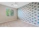 Bright bedroom with a ceiling fan, carpet, and unique patterned accent wall at 2670 E Parkview Dr, Gilbert, AZ 85295