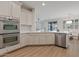 Modern kitchen with stainless steel appliances, white cabinetry, and a breakfast bar area at 2670 E Parkview Dr, Gilbert, AZ 85295