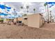 Exterior view of a home with a gravel yard and palm trees under a partly cloudy sky at 2700 E Allred Ave # A3, Mesa, AZ 85204