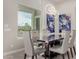 Elegant dining room with neutral color walls and table next to a large picture window for natural light at 29606 N Tarragona Dr, Peoria, AZ 85383