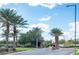 Entryway lined with palm trees, blue skies and desert landscape at 29606 N Tarragona Dr, Peoria, AZ 85383