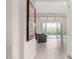 Bright entryway with wood-look floors leads to an open floor plan with a modern black couch and a view of the outdoor pool at 29606 N Tarragona Dr, Peoria, AZ 85383