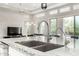 Modern kitchen featuring a spacious island with granite countertops, stainless steel faucet, and an open floor plan at 29606 N Tarragona Dr, Peoria, AZ 85383