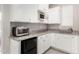 Kitchenette featuring white cabinetry, granite counters, and stainless-steel microwave at 29606 N Tarragona Dr, Peoria, AZ 85383