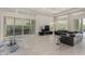 Open floor plan living room with access to back patio and pool area with a modern black wraparound couch at 29606 N Tarragona Dr, Peoria, AZ 85383