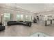 Bright open living room with a black wraparound couch, views of the backyard pool, and an open kitchen at 29606 N Tarragona Dr, Peoria, AZ 85383