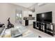 Cozy living area open to kitchen featuring modern appliances, laminate floors, and neutral color palette at 29606 N Tarragona Dr, Peoria, AZ 85383