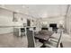 Open floor plan with kitchen island, dining table, and living area with floor to ceiling windows for natural light at 29606 N Tarragona Dr, Peoria, AZ 85383