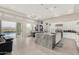 Open floor plan with living room, dining table, kitchen island and view of the pool through sliding glass doors at 29606 N Tarragona Dr, Peoria, AZ 85383
