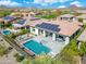 Areal view of a backyard pool and spa with covered patio, lounge seating, and mountain views at 29606 N Tarragona Dr, Peoria, AZ 85383