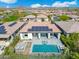 Areal view of a backyard pool and spa with covered patio, lounge seating, and mountain views at 29606 N Tarragona Dr, Peoria, AZ 85383