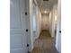 Bright hallway featuring wood-style tile flooring, white trim, and access to other rooms at 32723 N Newby Dr, San Tan Valley, AZ 85140