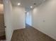 A well-lit hallway with wood-look tile flooring and access to the bathroom at 32723 N Newby Dr, San Tan Valley, AZ 85140