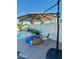 Backyard retreat with pool, firepit, and comfortable seating beneath a large patio umbrella at 3807 E Altadena Ave, Phoenix, AZ 85028