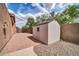 View of a backyard patio with brick pavers, a storage shed, and a low block wall around the yard at 40202 N Oakhurst Ct, Anthem, AZ 85086