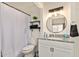 Stylish bathroom showcasing granite countertop, shelving, and modern round mirror at 406 E Washington Ave # C, Gilbert, AZ 85234