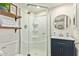 Updated bathroom features a stand up shower, shelving, and a vanity with navy blue cabinets at 406 E Washington Ave # C, Gilbert, AZ 85234