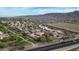 Expansive aerial view of a neighborhood in front of mountains, showcasing neatly arranged homes with pools and community green spaces at 4311 W Siesta Way, Laveen, AZ 85339