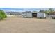 Barn and shed sit on a spacious lot with a dirt yard, mountains in the distance and a white fence at 4311 W Siesta Way, Laveen, AZ 85339