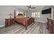 Bedroom with gray walls, wood-look floors, natural light, ceiling fan, and red patterned bedspread at 4311 W Siesta Way, Laveen, AZ 85339