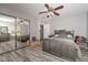 Bedroom with gray walls, wood-look floors, mirrored closet and ceiling fan at 4311 W Siesta Way, Laveen, AZ 85339