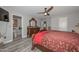 Bedroom featuring en suite bath, gray walls, wood-look floors and ceiling fan at 4311 W Siesta Way, Laveen, AZ 85339