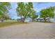 View of the long gravel driveway, home, and outbuildings at 4311 W Siesta Way, Laveen, AZ 85339