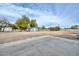 Spacious lot featuring a dirt yard, accessory building, and white fencing beneath a cloudy sky at 4311 W Siesta Way, Laveen, AZ 85339