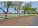 Landscaped front yard features a white fence, mature trees, and green grass at 4311 W Siesta Way, Laveen, AZ 85339
