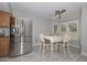 Bright kitchen features stainless steel refrigerator, eating space with natural light, and gray tile flooring at 4311 W Siesta Way, Laveen, AZ 85339