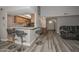 Bright living space with a kitchen bar, gray toned wood floors and a leather sectional sofa at 4311 W Siesta Way, Laveen, AZ 85339