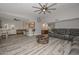 Open-concept living room featuring a large leather sectional, eat in kitchen and gray toned wood flooring at 4311 W Siesta Way, Laveen, AZ 85339