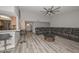 Comfortable living room with gray toned wood flooring, wet bar and a large black leather sectional sofa at 4311 W Siesta Way, Laveen, AZ 85339