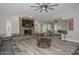 Inviting living room boasts gray flooring, stone fireplace, and open layout to dining area at 4311 W Siesta Way, Laveen, AZ 85339