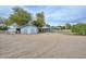 Exterior shot showcasing home, outbuilding, and white fencing on desert property at 4311 W Siesta Way, Laveen, AZ 85339
