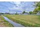 Large, grassy yard bordered by a white fence, home, and mature trees at 4311 W Siesta Way, Laveen, AZ 85339