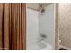 A traditional bathtub with a white tiled wall and a brown curtain in the bathroom at 4531 W Flint St, Chandler, AZ 85226