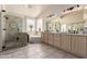 A bathroom featuring both a shower and a bathtub surrounded by beige tiling, windows, and a long vanity at 4531 W Flint St, Chandler, AZ 85226