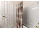 A bathroom with a white door, a bathtub, and a shower curtain with a striped pattern at 4531 W Flint St, Chandler, AZ 85226