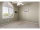 Empty bedroom with light green walls, neutral carpet, and a large window with white shutters at 4531 W Flint St, Chandler, AZ 85226