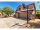 View of a two-story home with a basketball hoop, three-car garage and desert landscaping at 4531 W Flint St, Chandler, AZ 85226