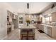 Well-lit kitchen featuring an island with seating, tiled countertops, and modern appliances at 4531 W Flint St, Chandler, AZ 85226