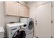 A laundry room featuring a side-by-side washer and dryer set and cabinets for storage at 4531 W Flint St, Chandler, AZ 85226