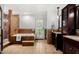 Bathroom featuring a soaking tub and dual sink vanity with earth tone tile at 4558 E Vista Dr, Phoenix, AZ 85032