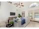 Stylish living room with vaulted ceilings, modern ceiling fan, and access to an outdoor pool area at 4558 E Vista Dr, Phoenix, AZ 85032